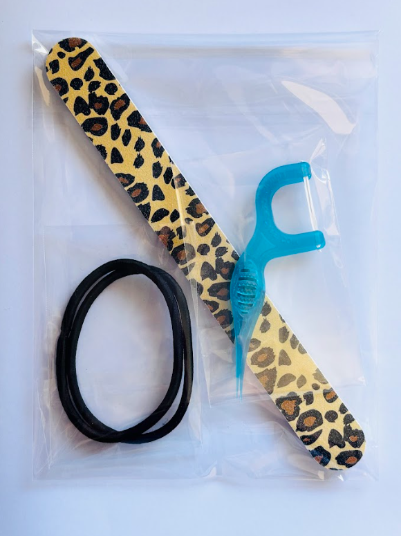Lifepac nail file, two hair ties, and two tooth pickers on a white background for personal grooming and hair styling.